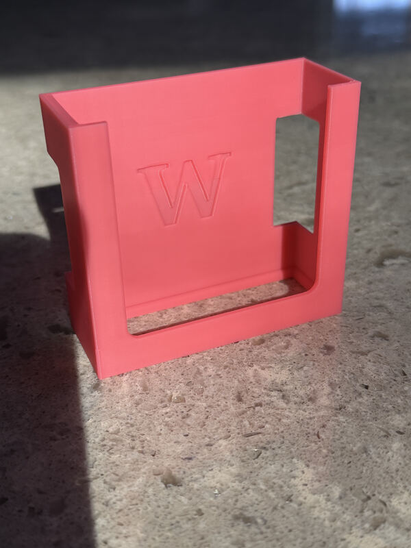 Two lime green 3D printed Waggle monitor kennel mounts sitting in sunlight.